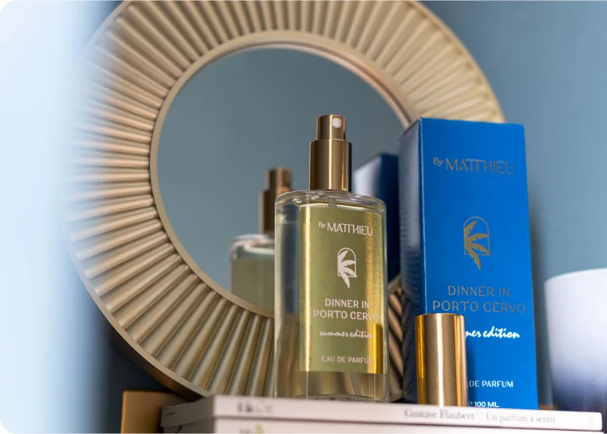 Flacone by Matthieu con box blu in set editoriale davanti a uno specchio