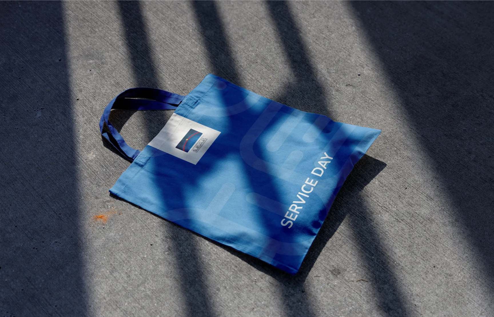Shopper blu Seap Service Day fotografata a terra con ombre nette